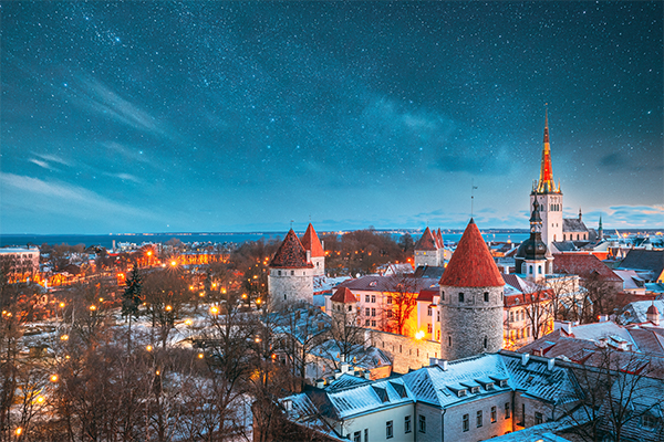 Tallinn, Estonia. Night Starry Sky Above Old Castle Walls Architecture. Cityscape Skyline In Old